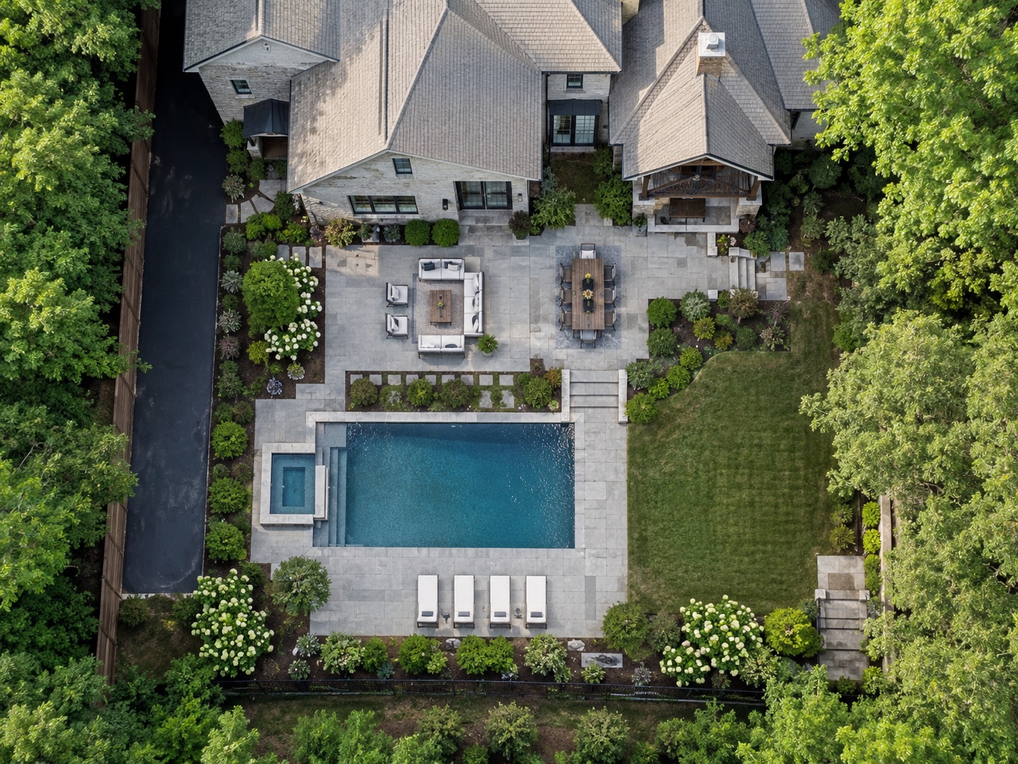 Aerial view of a Legacy Living Builders backyard — pool, spa, stone terraces, and pavilion